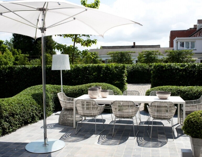 eettafel-parasol-op-stenen-ondergrond-tegels-langs-haag