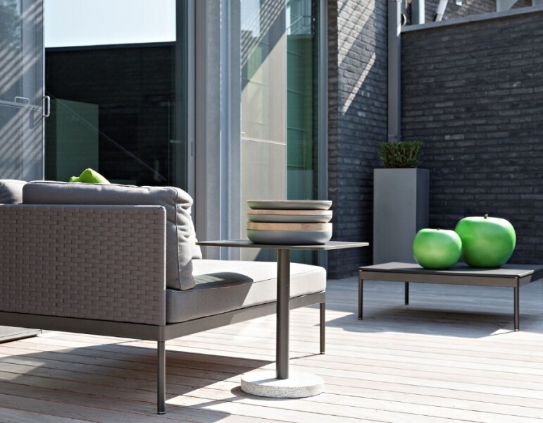 gevlochten-tuinstoel-met-tafel-in-zon-grijs-groen