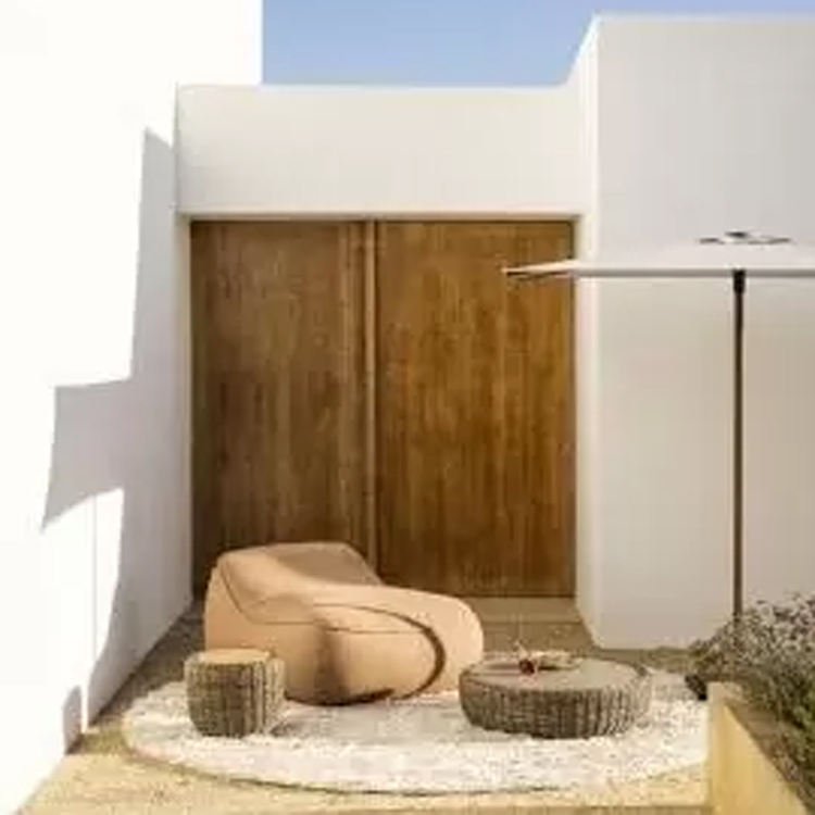 jardinico bolsa loungezetel met rieten bijzettafels langs wit huis op rond wit tapijt