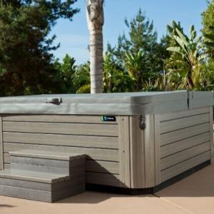 beige jacuzzi in tuin op stenen vloer schuin zijaanzicht