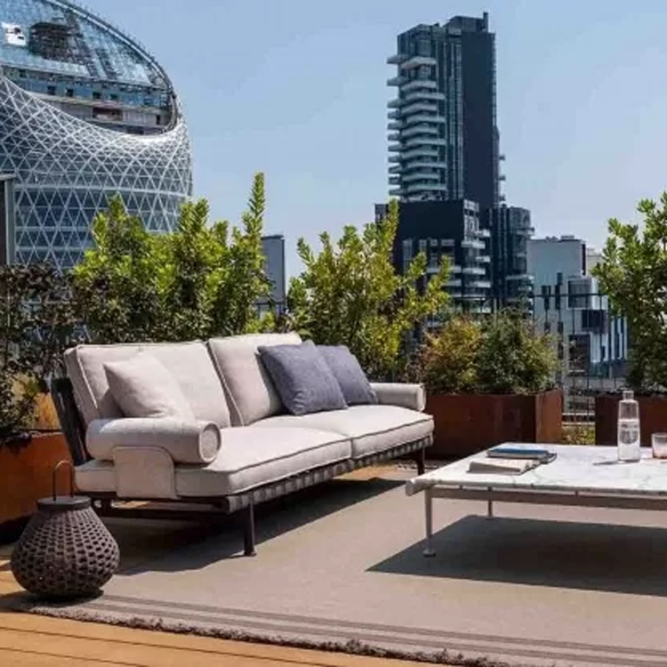bruine loungeset met beige kussens op een dakterras zijaanzicht met stadszicht