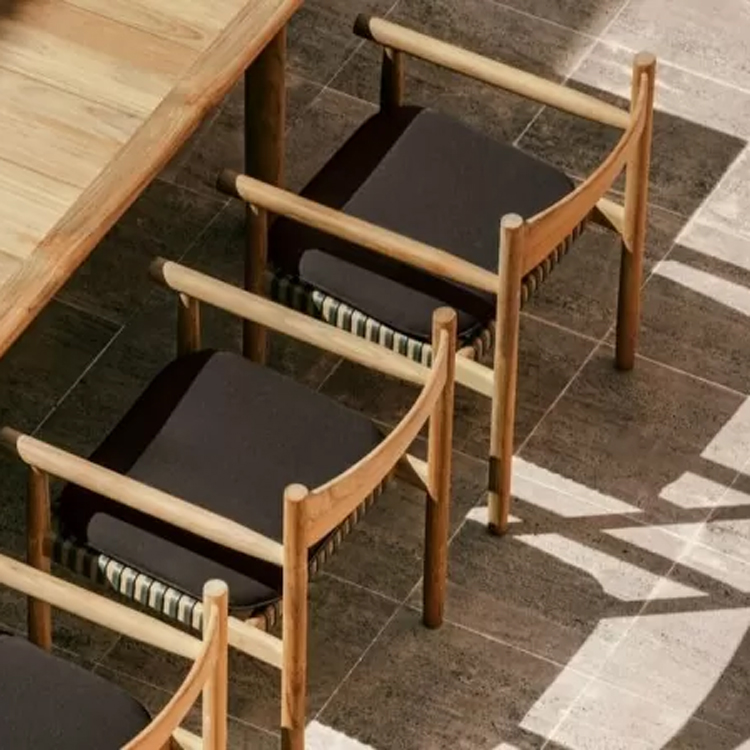 chaise et table de jardin en bois coussin noir vue sur sol carrelé | dedon tibbo