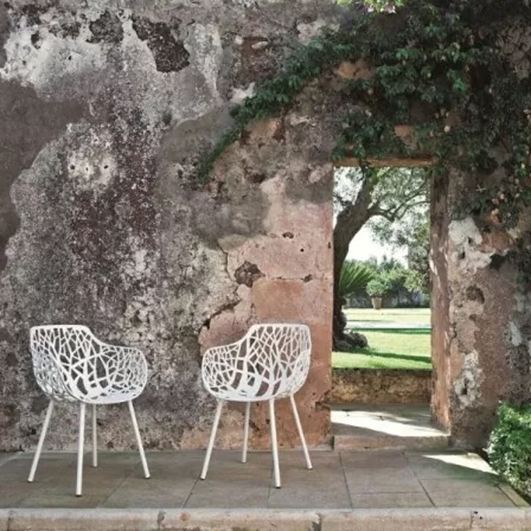 chaises de jardin rapides de couleur blanc forêt le long d'un ancien mur de pierre avec passage