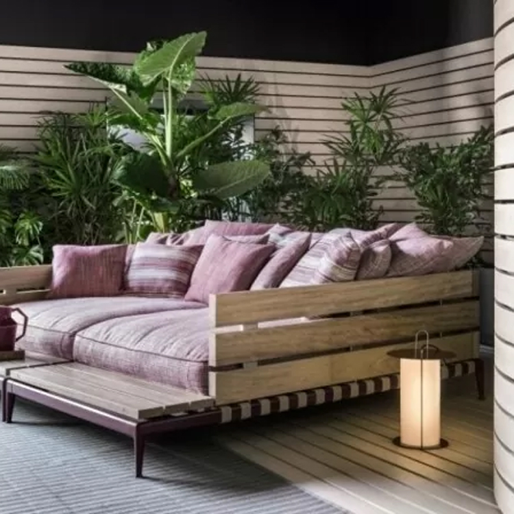 ligbed met roze kussens met planten rond in een relax ruimte
