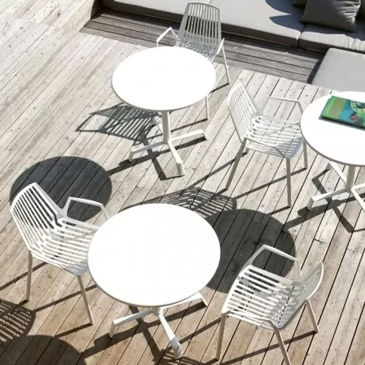 table de terrasse rion avec chaises plateau incliné blanc sur plateforme en bois avec coussins de salon le long de la terrasse