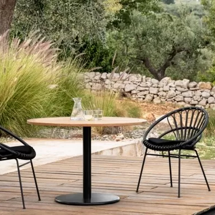 vincent sheppard roxanne dining chair ronda bistro table donker op een houten paltform en groene tuin