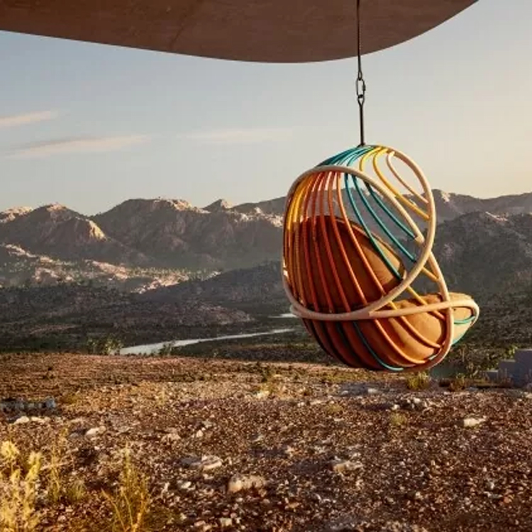 hangende loungestoel in de desert met berglandschap