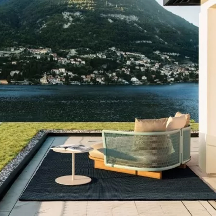 kettal mesh loungestoel lichtgroen langs water oppervlak